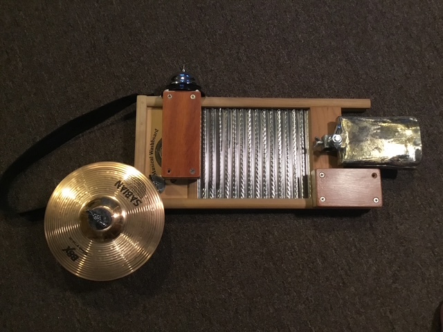 This is my washboard. The cowbell is probably about one hundred years old. It was flattened, cracked and had holes in it. I straightened it out, filled the holes and cracks with brazing rod, and added a mounting bracket. I liked the sound of it. I did not
